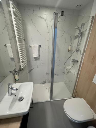 a bathroom with a shower and a toilet and a sink at Wilanów Residence Apartments in Warsaw