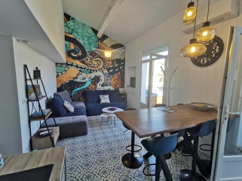 un salon avec un canapé bleu et une table dans l'établissement T3 terrasse classé 4 étoiles le Poulpe 200m front de mer, à Banyuls-sur-Mer