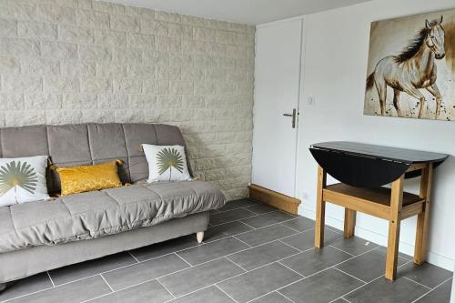 un salon avec un canapé gris et une table dans l'établissement Appartement cosy neuf, à Saint-Sornin-Lavolps