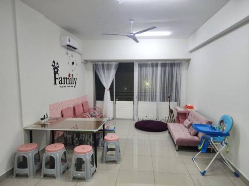 a living room with a couch and a table and chairs at Cozy FamiLee Homestay in Simpang Ampat