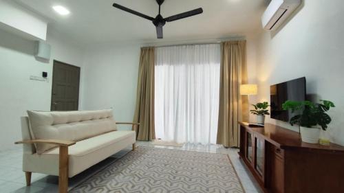 a living room with a couch and a television at Homestay Anggerik 56 Saujana Utama in Sungai Buluh