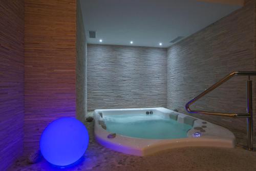 uma casa de banho com banheira e iluminação roxa em Hotel Negritella em Passo del Tonale