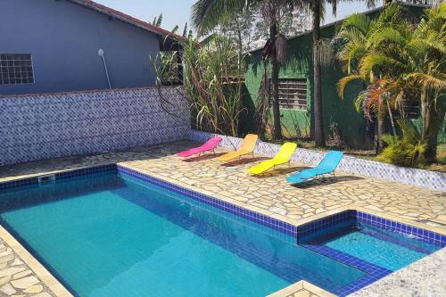 une piscine avec trois chaises longues à côté dans l'établissement Sinta-se em casa com diversão!, à São Paulo