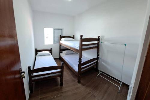 Cette petite chambre comprend 2 lits superposés et une porte. dans l'établissement Sinta-se em casa com diversão!, à São Paulo