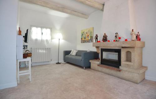 un salon avec un canapé bleu et une cheminée dans l'établissement Maison de Village avec jardin dans Centre historique, à Eyguières