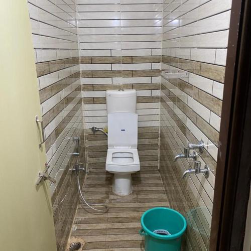 a small bathroom with a toilet in a stall at Anant Shree Guest House Ac Room With Free Wifi Hotel Gondia in Gondia