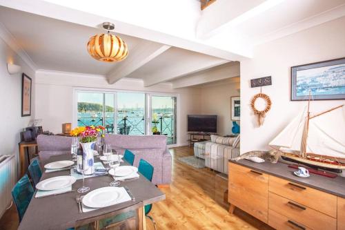 a living room with a table and a sailboat on the wall at Janes Court, Packet Quays in Falmouth