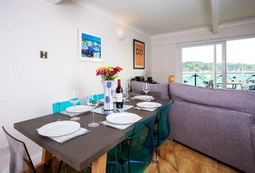 a dining room with a table and a couch at Janes Court, Packet Quays in Falmouth
