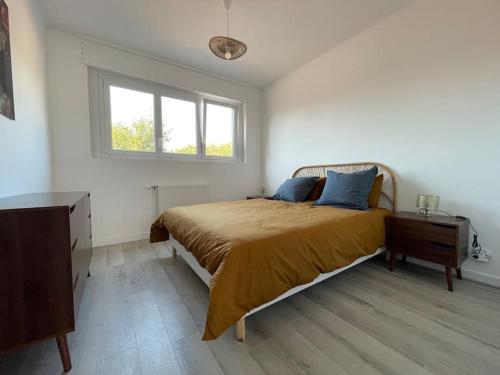 une chambre avec un grand lit et une fenêtre dans l'établissement Appartement élégant proche mer, à Dunkerque