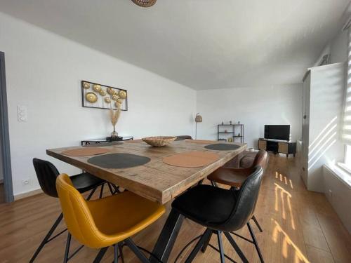 une salle à manger avec une table et des chaises en bois dans l'établissement Appartement élégant proche mer, à Dunkerque