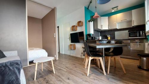 une petite cuisine avec une table et des chaises dans une pièce dans l'établissement Le calme au centre ville, à Gréoux-les-Bains