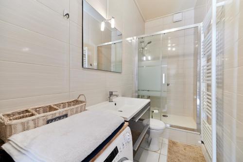 a white bathroom with a sink and a toilet at Au bon air de Villers - plage à 200 mètres in Villers-sur-Mer