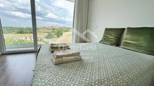 une chambre avec un grand lit avec une grande fenêtre dans l'établissement Magnolienhaus, à Capelas