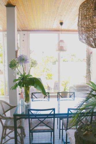 a dining room with a glass table and chairs at Vila Vale Guest House - Surf & Yoga in Charneca