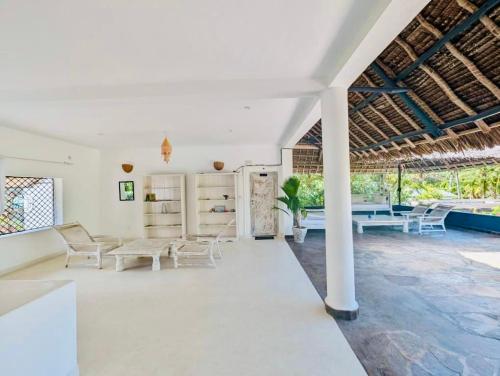a living room with white furniture and a ceiling at WHITE Nyumba Malindi in Malindi