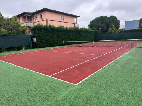 a tennis court with a house in the background at le loft Geek in Toulouse