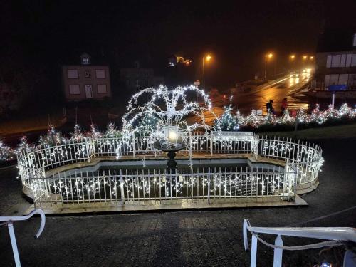 a fountain with christmas lights in a city at night at Perfect Gites In Normandy in Saint-Sauveur-de-Chaulieu