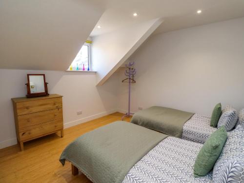 a attic bedroom with two beds and a dresser at Ocean View in Alnwick