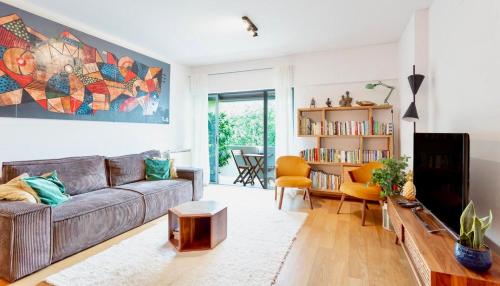 a living room with a couch and a book shelf at Lisbon AP centro Aeroporto Expo Parque das nações in Lisbon