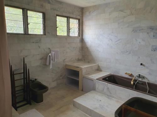 a white bathroom with a sink and a sink at Villa Cacao in Abidjan