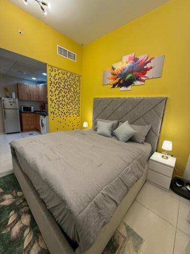 a bedroom with a large bed with a yellow wall at Livincci - Luxury Studio in Dubai Marina - 15 in Dubai