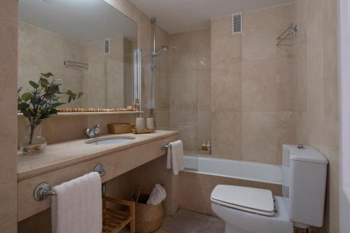 łazienka z toaletą, umywalką i wanną w obiekcie Aquamarine apartment in Marina Sotogrande w mieście Sotogrande