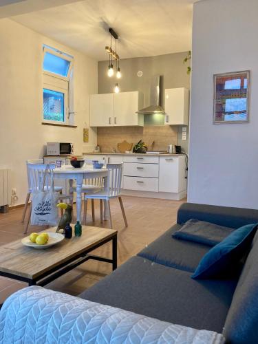 un salon avec un canapé et une table et une cuisine dans l'établissement A 2 pas Maison 3 couchages, à Dieppe