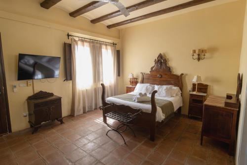 a bedroom with a bed and a television in a room at Hostal La Riera de Peratallada in Peratallada