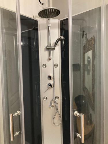 une douche avec une porte vitrée dans une salle de bain dans l'établissement A 2 pas Maison 3 couchages, à Dieppe