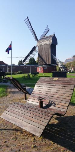 a wooden deck in front of a windmill at Landhaus Löwenzahn in Dornum