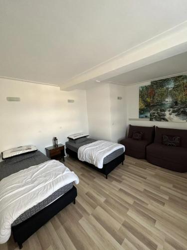 une chambre avec deux lits et un canapé dans l'établissement Appartement confortable à Saint-Éloy-les-Mines 55 m² pour 6 personnes, à Saint-Éloy-les-Mines