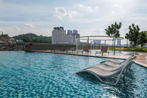 a swimming pool with two chairs in the water at Cheras Kuala Lumpur luxury condo in Cheras