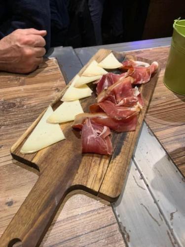 a cutting board with meat and cheese on a table at Chalet 6-8 pers St Lary Alt1700m -100mdespistes classé 4 étoiles in Saint-Lary-Soulan