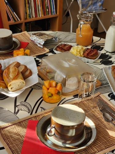 a table topped with plates of breakfast foods and orange juice at BnB Confort in Bruère-Allichamps