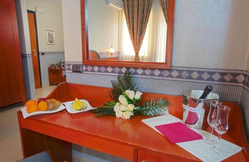a counter with fruit and flowers on it in a room at Hotel Kroma in Ragusa