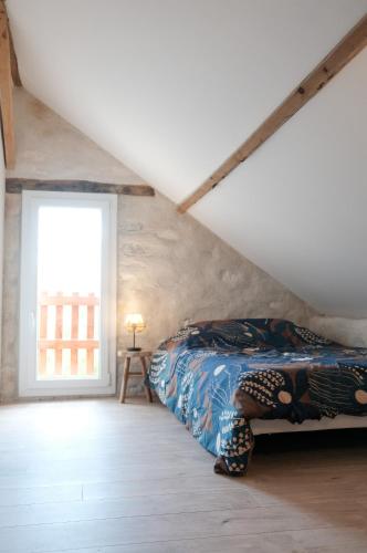 - une chambre mansardée avec une fenêtre dans l'établissement Un gîte en Creuse, à Bord-Saint-Georges