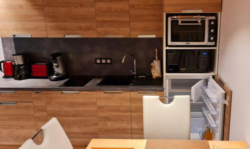 une cuisine avec un évier et un micro-ondes dans l'établissement Les Gets, centre Vieux Village, appartement T2 l'Eden, aux Gets