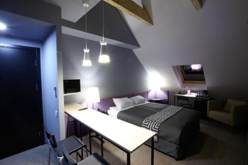 a bedroom with a bed and a table and a desk at Newport in Dnipro