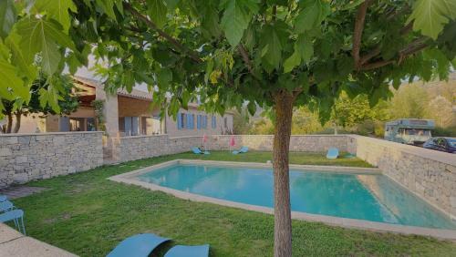 - une piscine dans une cour avec un arbre dans l'établissement La Fond de Mière, à Lachau