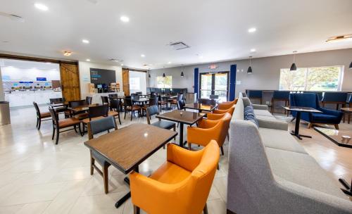 a restaurant with couches and tables and chairs at Holiday Inn Express & Suites Clermont SE - West Orlando by IHG in Orlando