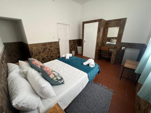 a bedroom with a bed with pillows and a mirror at Bahnhof Hotel Usakos in Usakos