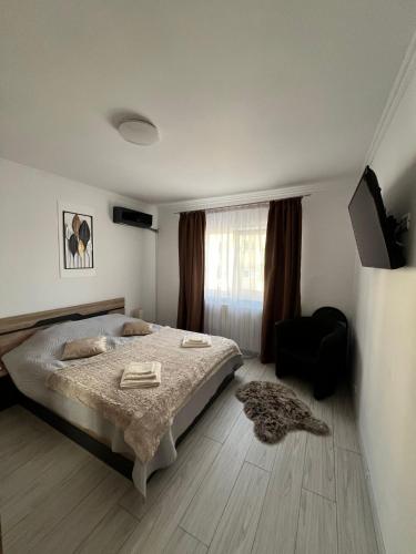 a bedroom with a bed and a chair and a window at Zen Studio Onesti in Onești