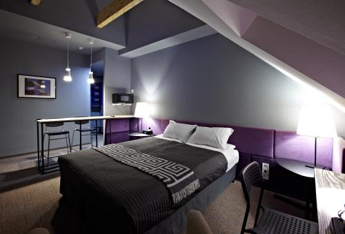 a bedroom with purple walls and a bed with a table at Newport in Dnipro