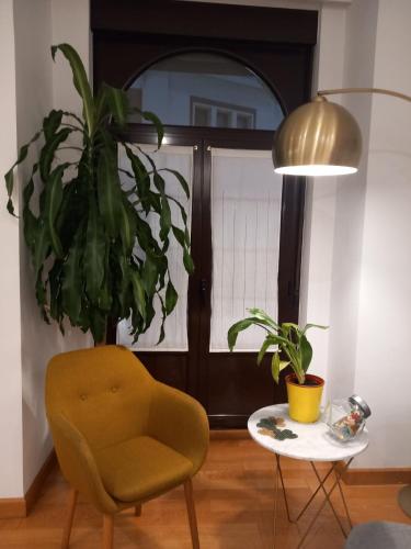a room with a chair and a table with a plant at MenVal16 in Gijón