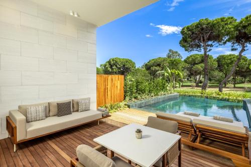 a living room with a pool in the background at Kempinski Hotel The Dome Belek in Belek