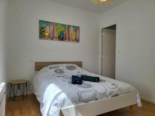 une chambre avec un lit avec un tableau sur le mur dans l'établissement T2 barbusse 4pers, 3lits, wifi, à Agen