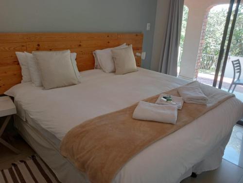 a large white bed with two towels on it at Seaside Lodge B&B in Ballito