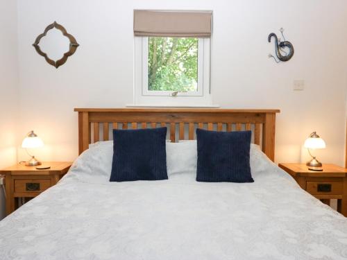 1 dormitorio con 1 cama blanca y 2 almohadas azules en Buttermere, en Ambleside