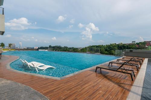 a swimming pool with lounge chairs on a building at Kuala Lumpur luxury MRT Suntex in Cheras