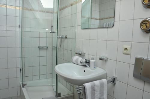 a white bathroom with a sink and a shower at Ferienwohnungen Wendelstein in Bad Feilnbach